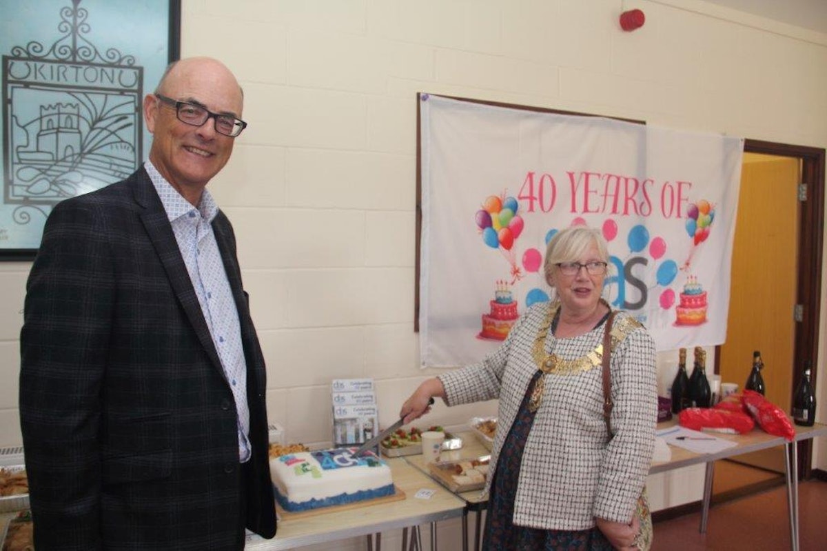 Guests cutting the cake at Disability Advice Service East Suffolk’s 40th anniversary celebration